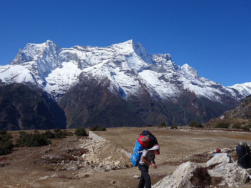 trekking porter carrying heavy load in everest